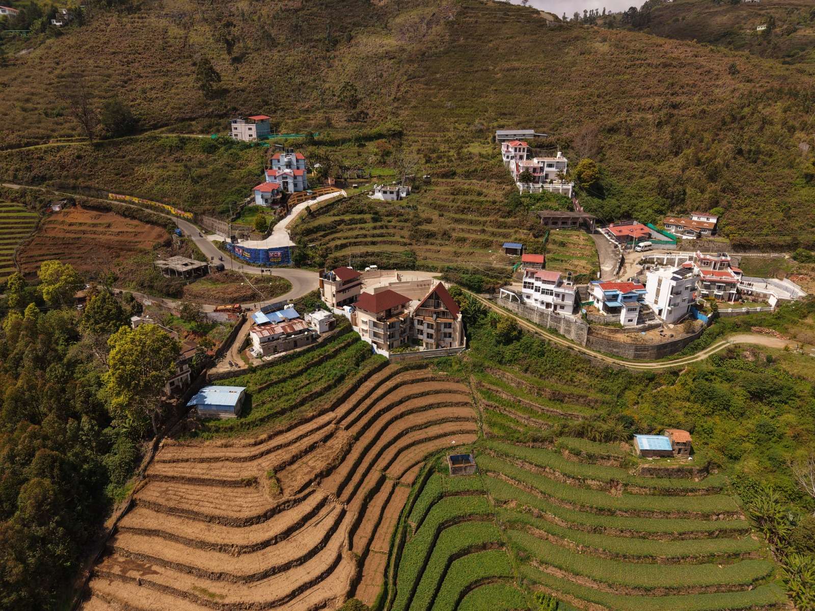 A drone view over the terraced hillside by day, with the property's buildings nestled among the fields.