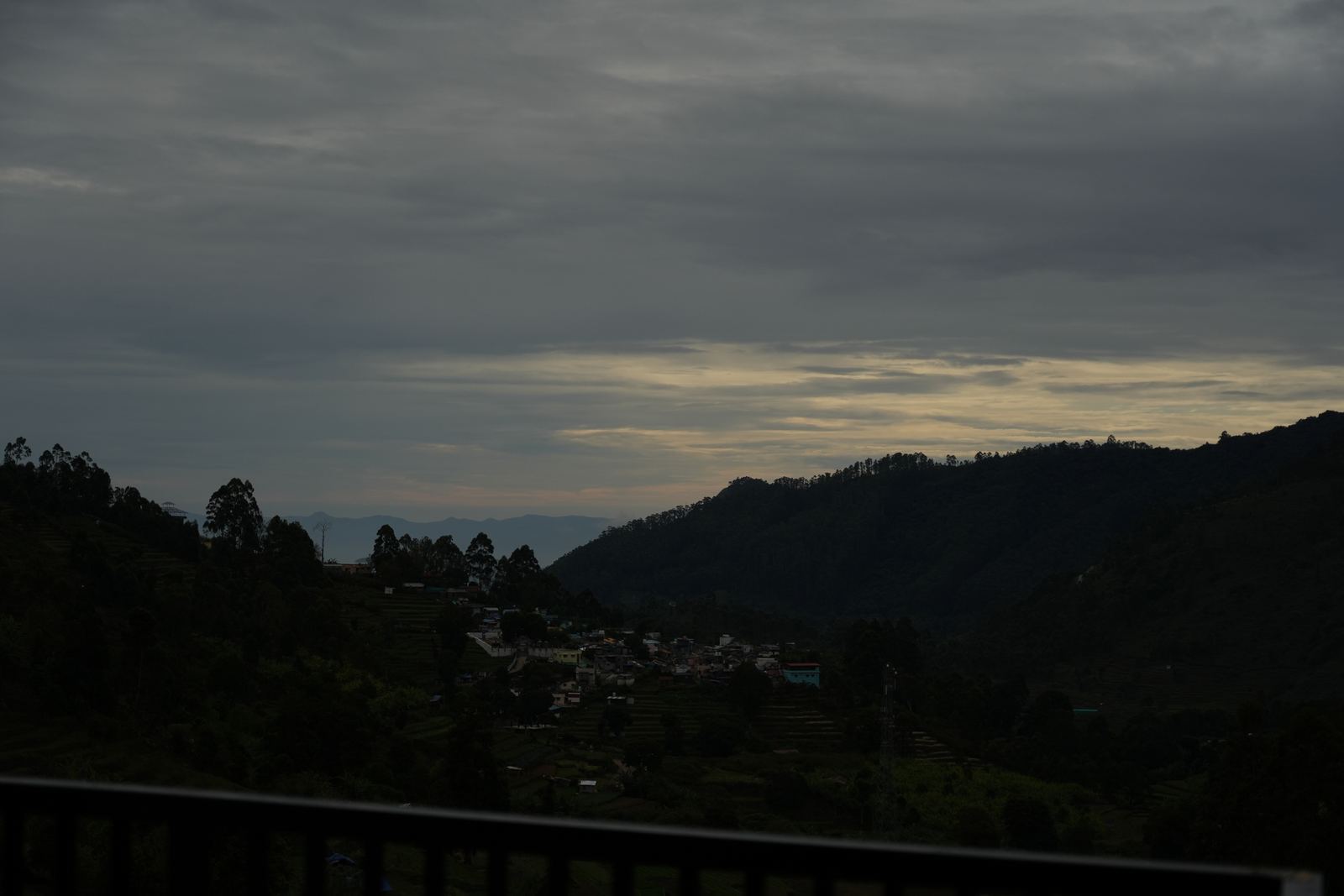 The valley at dusk, hillside villages lighting up beneath a darkening sky.